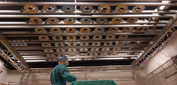 Das im Labor umgesetzte Konzept der neuen OP-Lampe. An einer Bühnentraverse über einem OP-Tisch ist ein Array aus 7x8 Strahlern aufgehängt